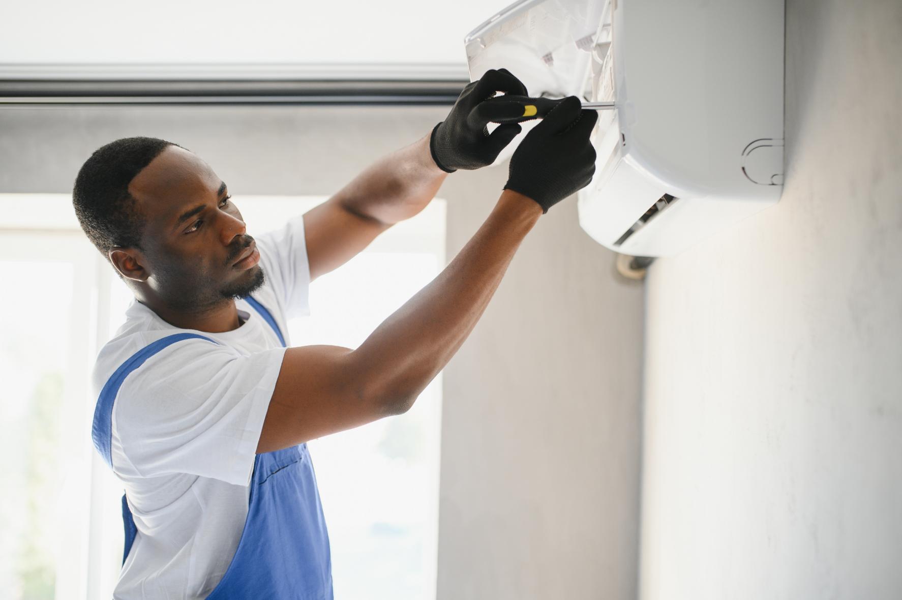 Certified HVAC technician repairing air conditioning unit