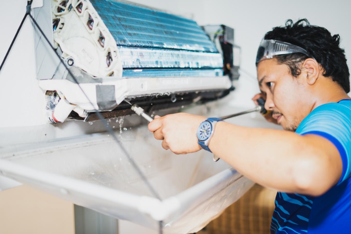Professional HVAC technician cleaning air conditioner